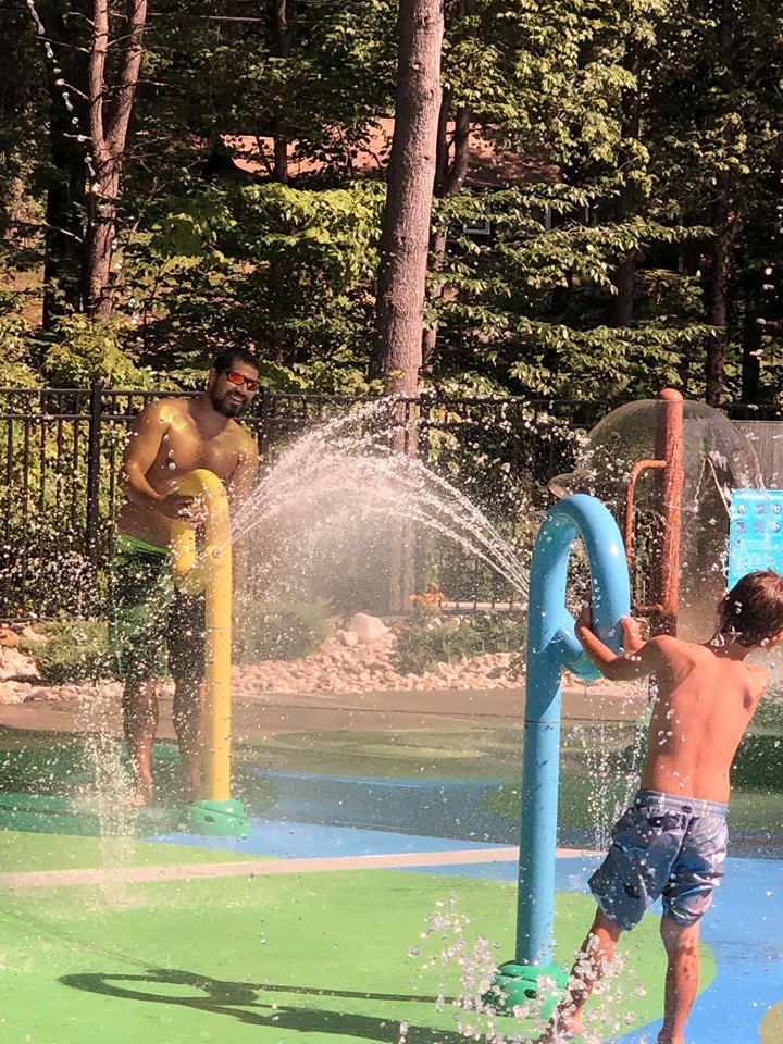 Dad and son firing water jets at each other