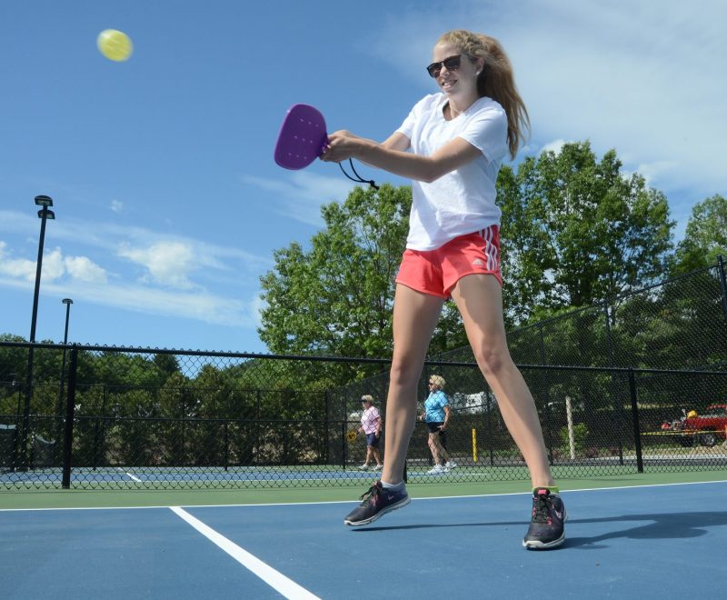 Guest playing pickle ball- swinging paddle to hit the ball