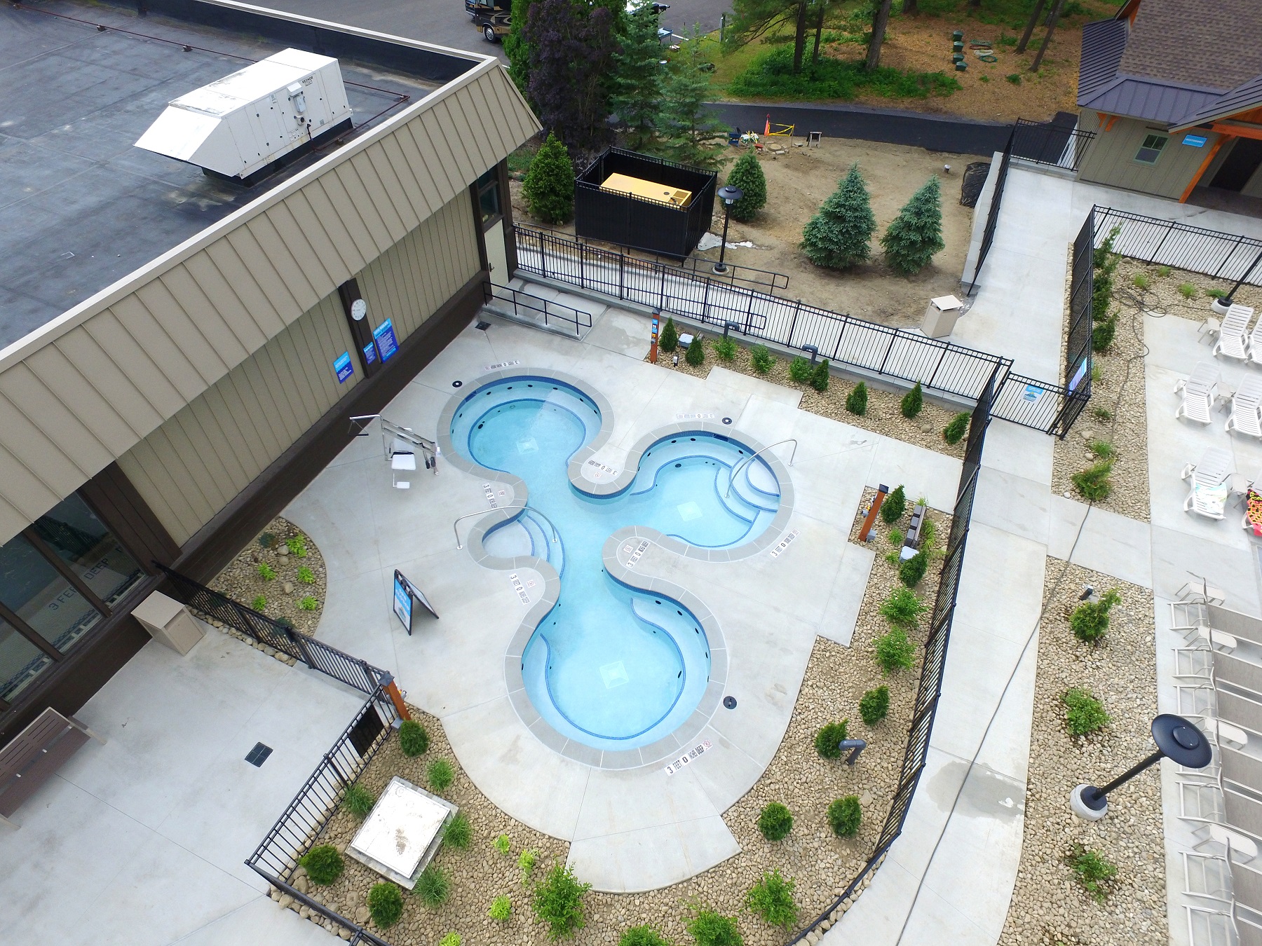 A birds eye view of Cascade Cove's hot tub area. 3 tubs are shown surrounded by a landscape area.