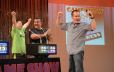 Game Show contestants  at game show pedestals on stage showing excitement and enthusiasm