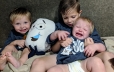Young kids holding crying baby