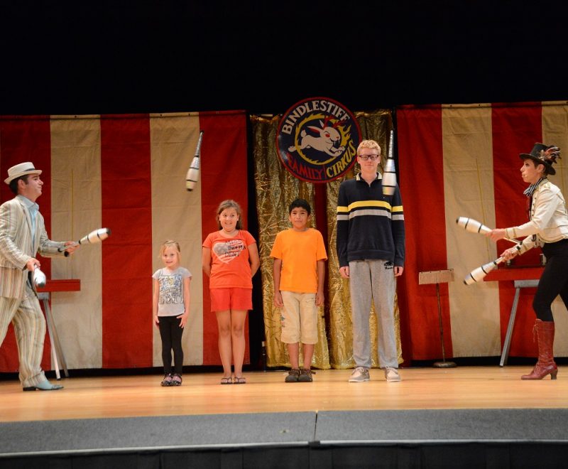 Volunteers onstage with juggling performers