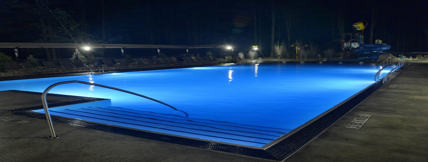 Night view of zero entry pool on the east end of park