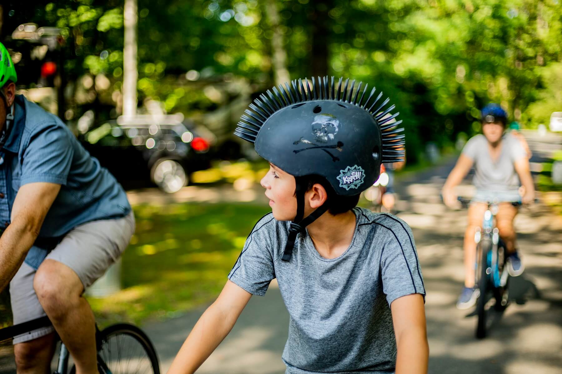 Young boy riding his bike wearing a spiky helmet