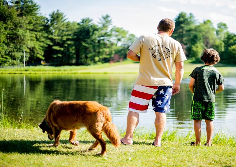 Man, boy, and dog at fishing pond