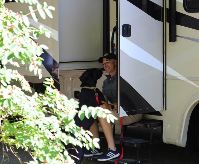 Man sitting on RV steps with dog