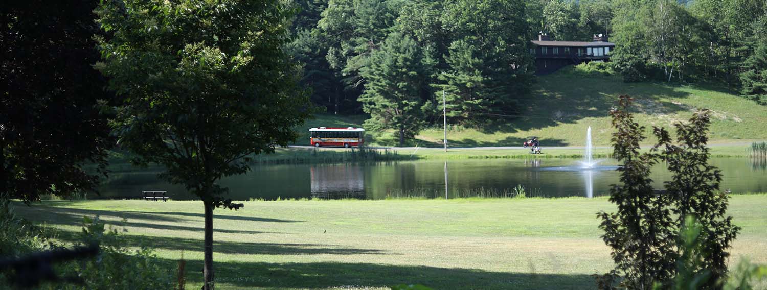 Park trolley driving next to pond