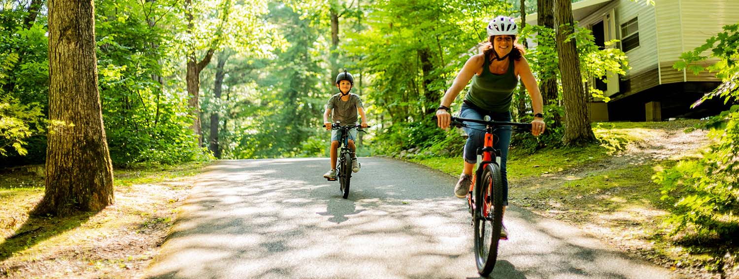 2 people riding bikes on path