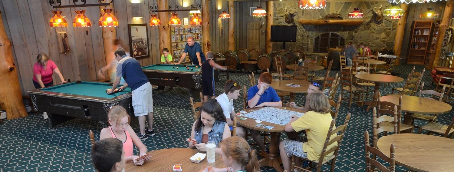 People gathered in game room playing pool and cards