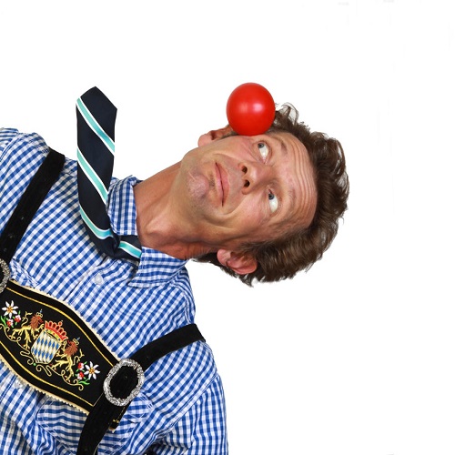 A man balancing a red ball on his face
