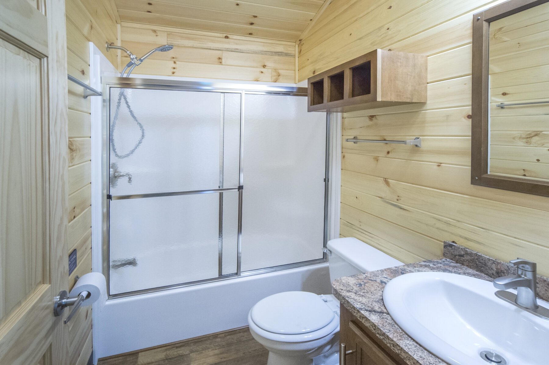 Cabin bathroom with sink, mirror, toilet and shower