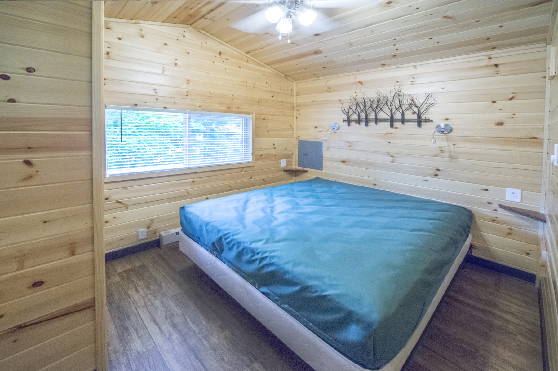 Queen bed in our new cabins with wall art hanging above