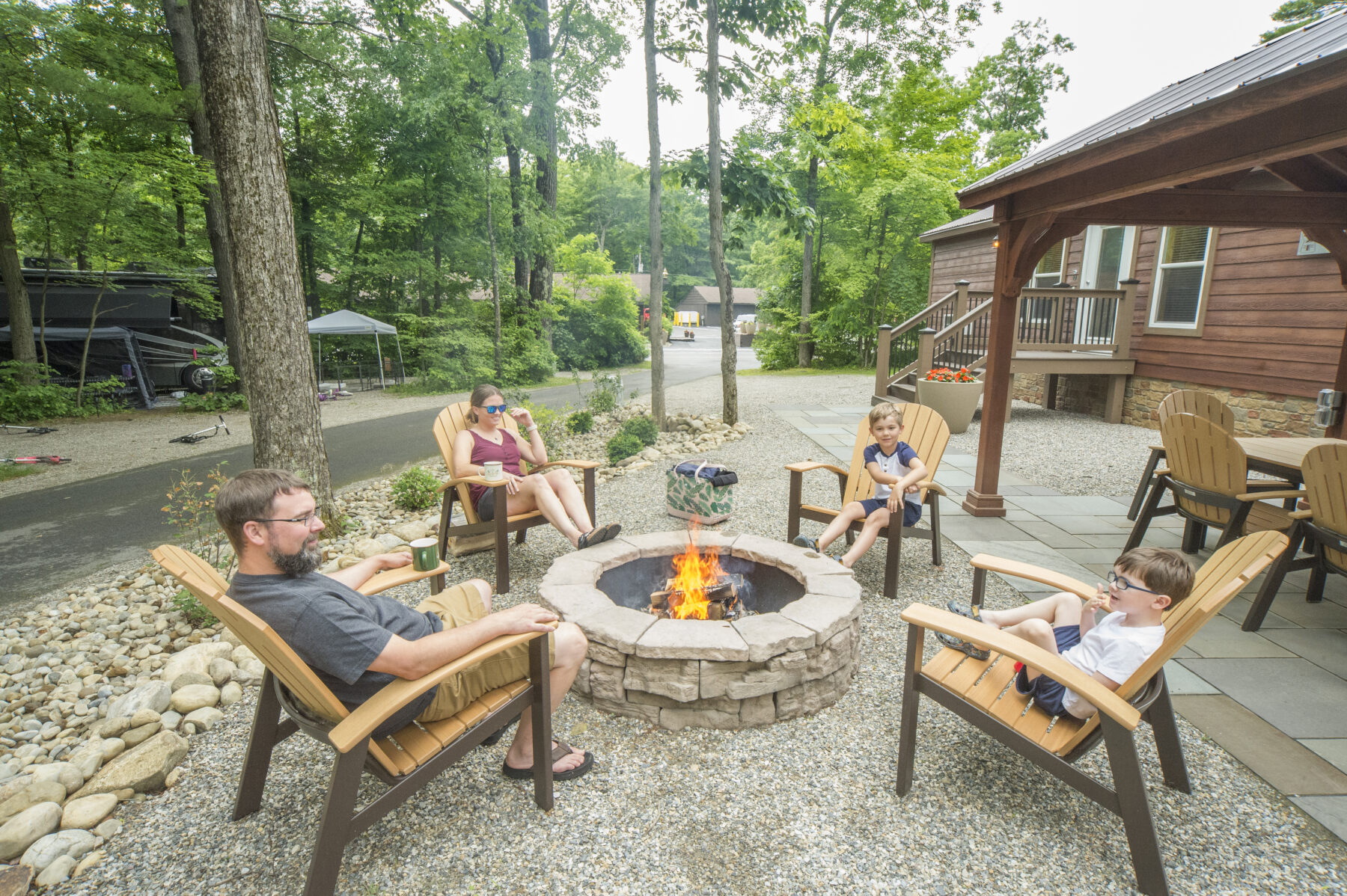 Parents and their two sons enjoying some time by the campfire at one of our new cabins