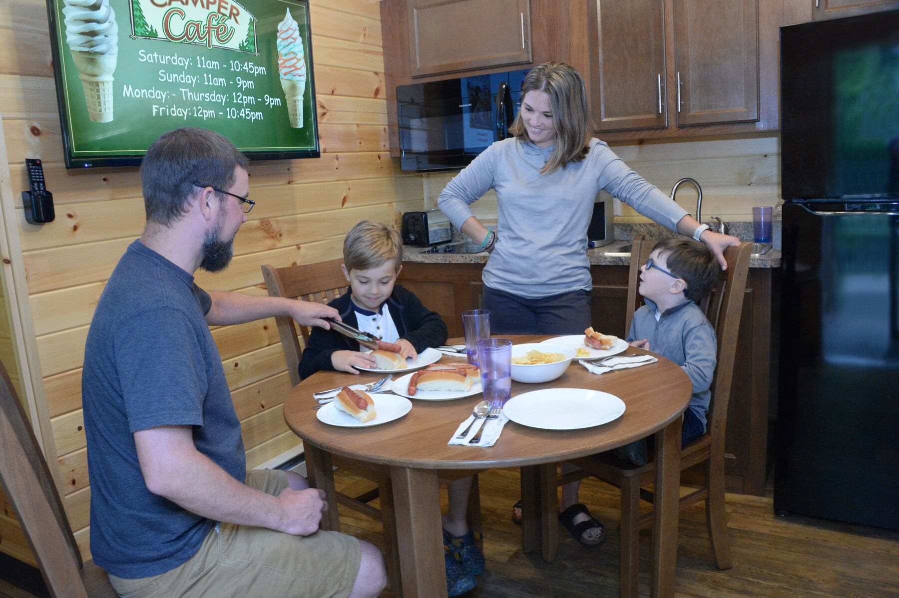 Family enjoying dinner at the kitchen table in one of our new cabins